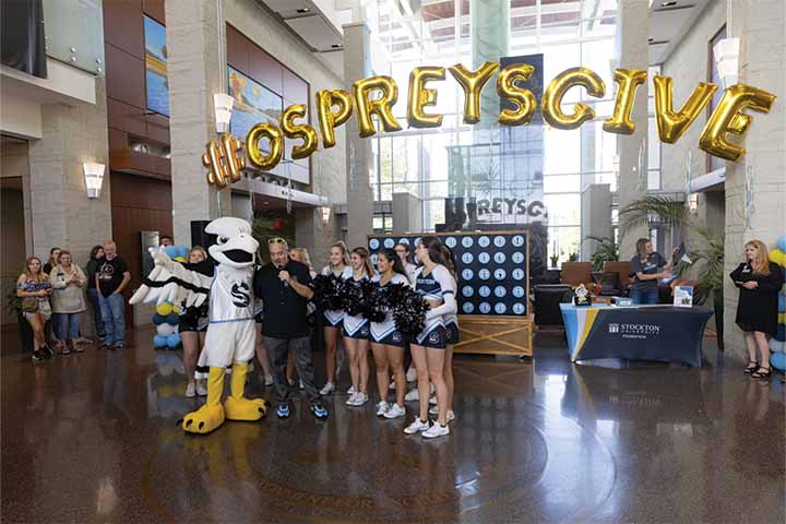 The Talon Osprey mascot poses with President Joe and members of the cheer team