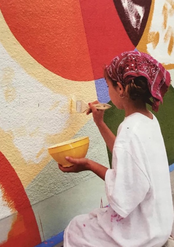 A young girl participates in the festivities by painting a wall