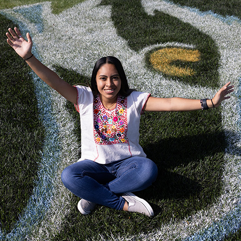 Katie Mendoza posing on the lawn of the Campus Center 