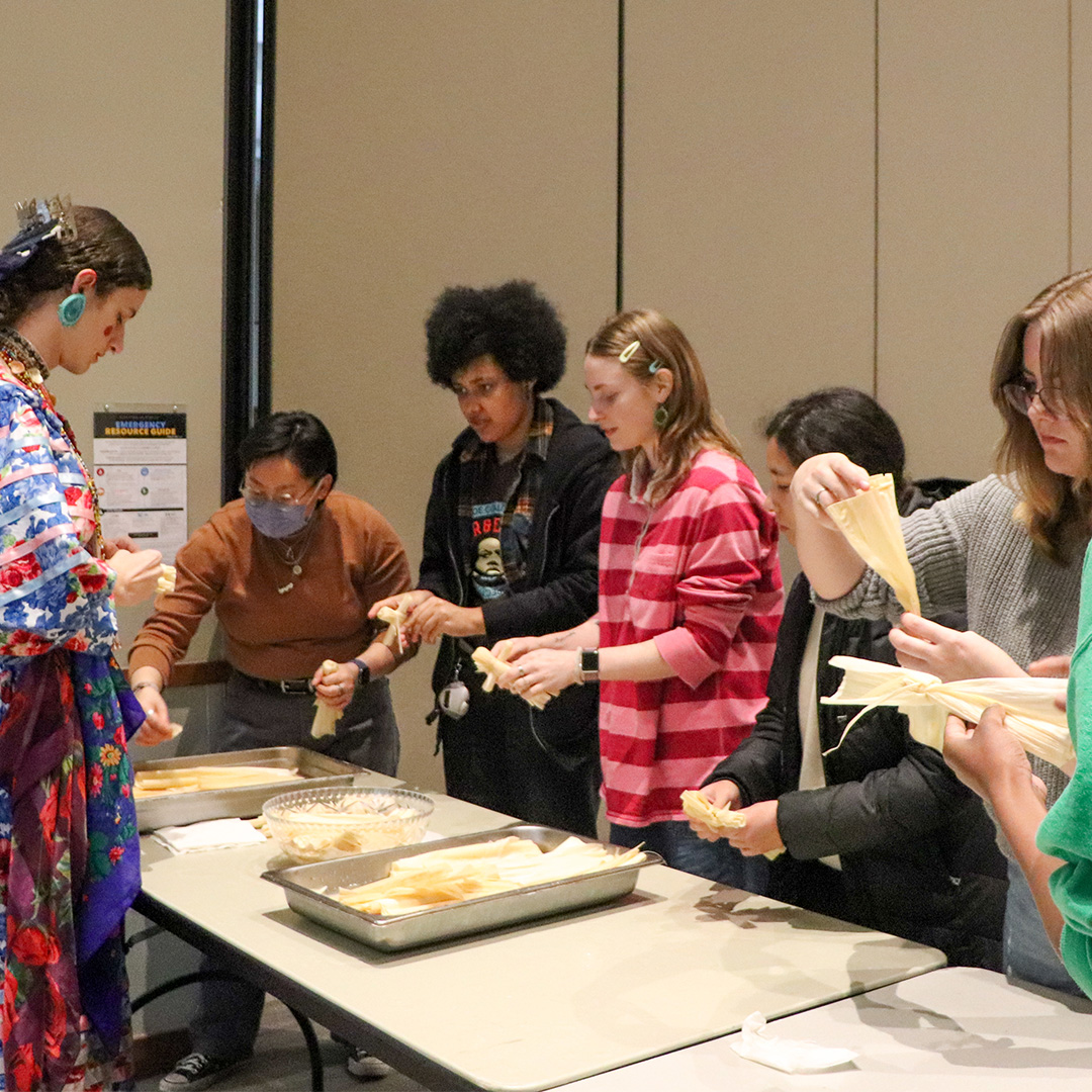 River teaching students how to make corn-husk dolls